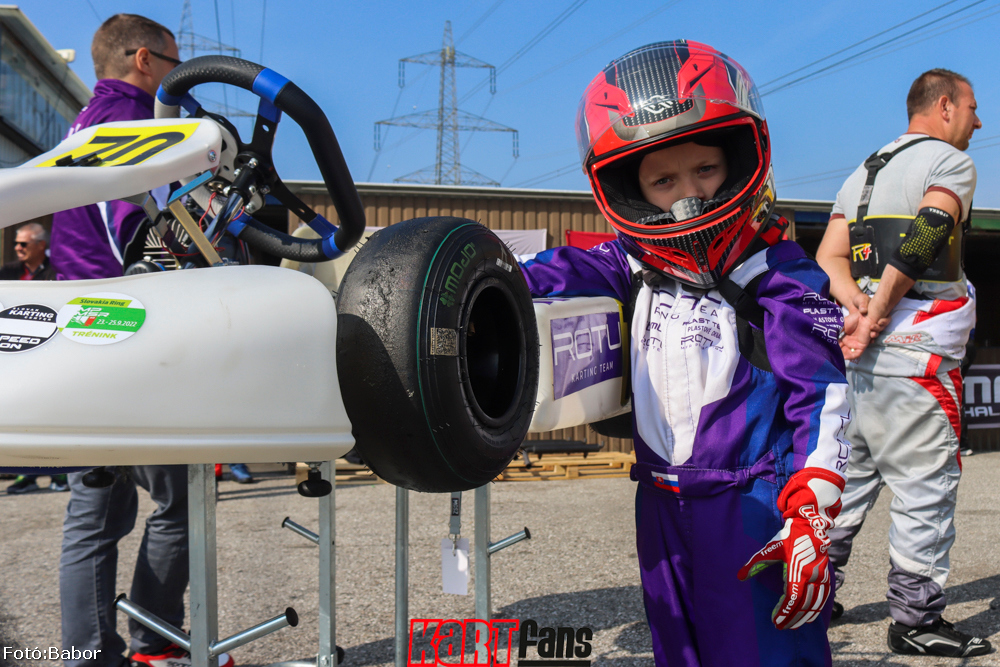 Dominik lila ROTU versenyruhában a gokart mellett