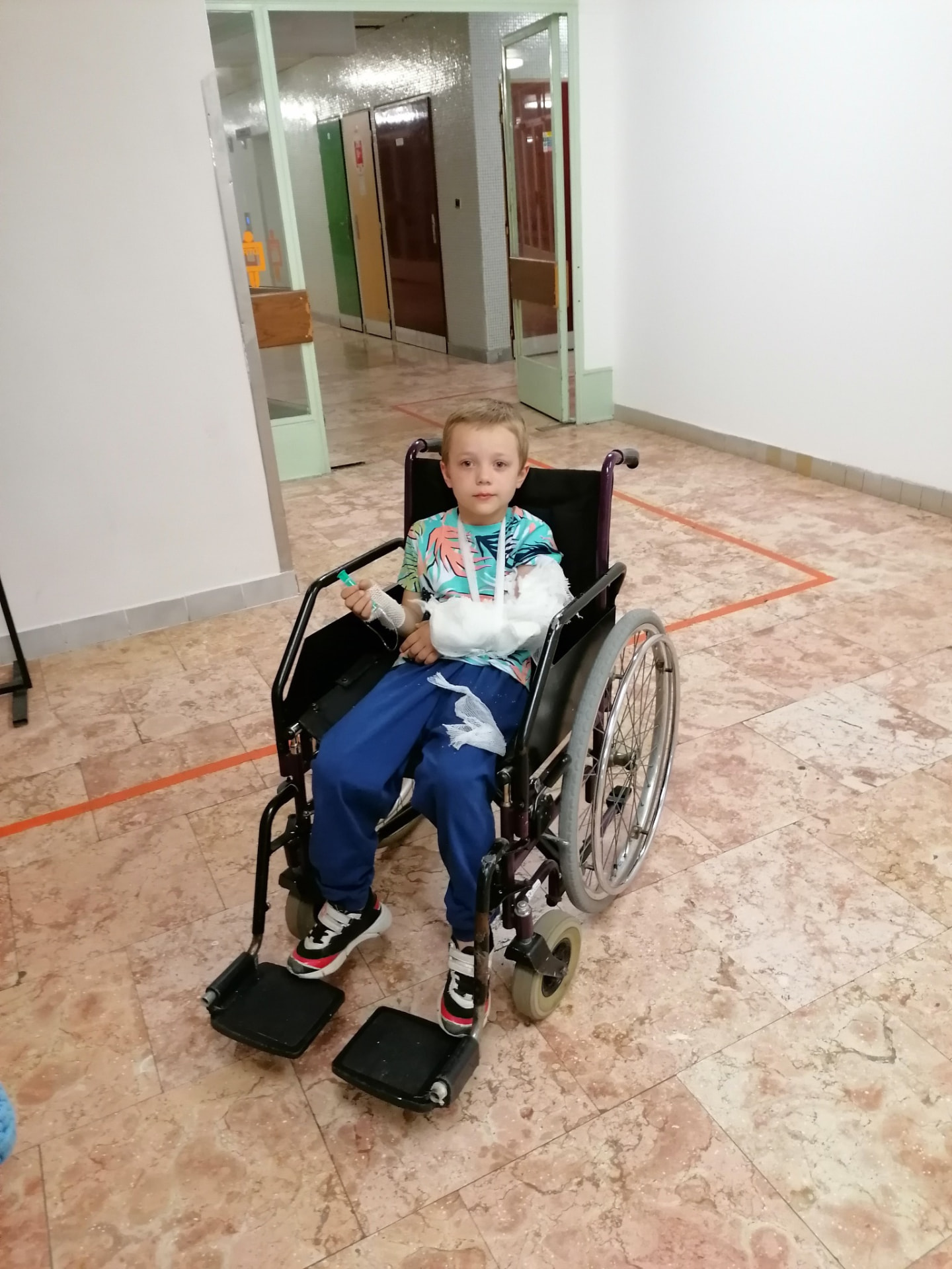 Dominik kerekesszékben, gipszelt karral